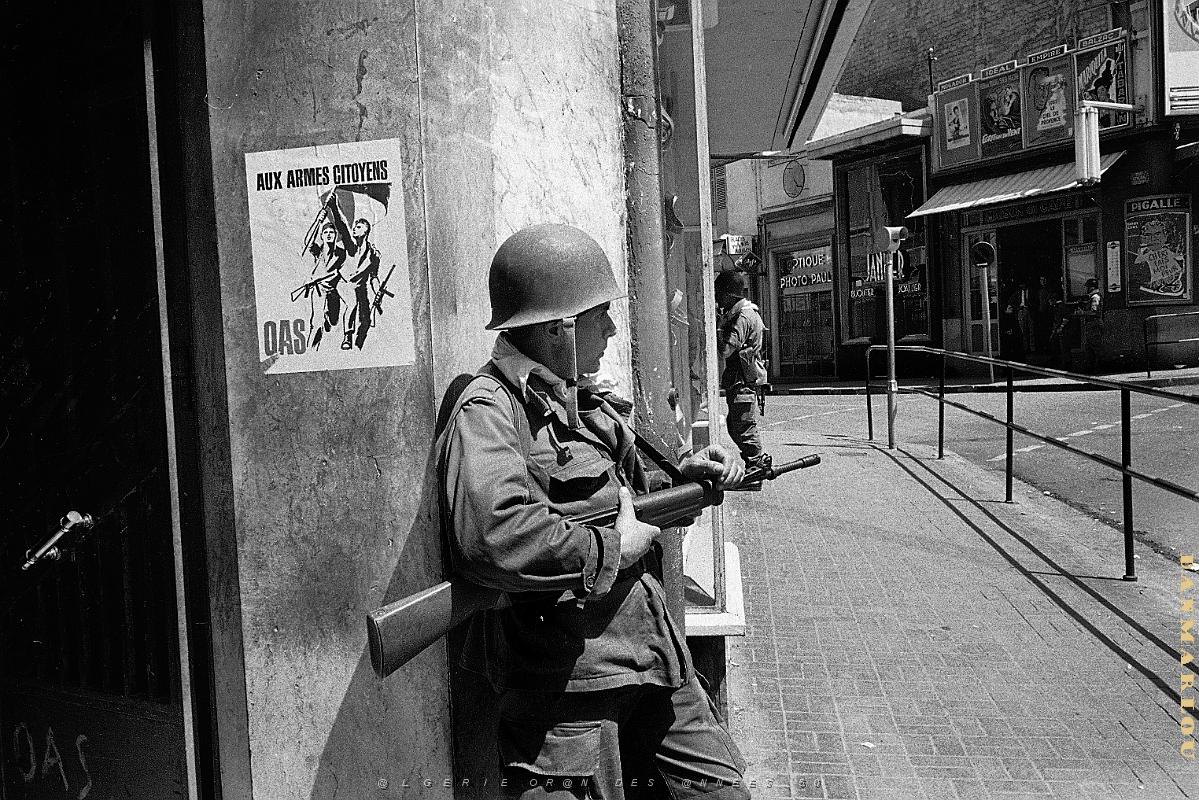 Oran- vues diverses (5).jpg - A French soldier guards a street corner in Oran, Algeria, May 15, 1962. On the wall is a poster of the right-wing nationalist Secret Armed Organization, calling for citizens to take up arms against Algerian independence. (AP Photo/Horst Faas)